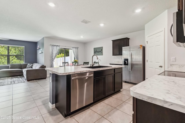 1809 Morely Dr, Cocoa, FL 32926 - kitchen featuring appliances with stainless steel finishes, light countertops, open floor plan, an island with sink, and light tile patterned floors