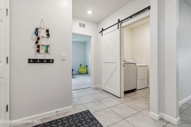 1809 Morely Dr, Cocoa, FL 32926 - hall featuring a barn door, independent washer and dryer, light tile patterned floors, and recessed lighting