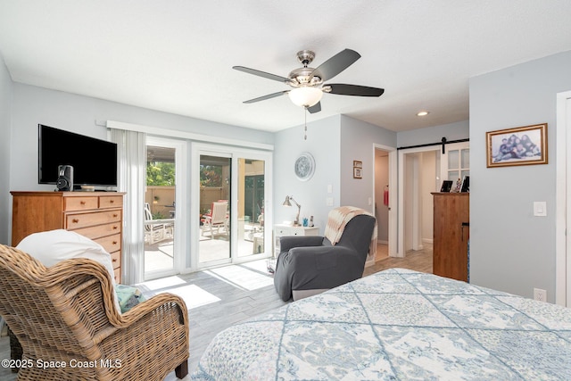 1100 SE Mitchell Ave Unit 204, Port St Lucie, FL 34952 - bedroom with access to exterior, a barn door, wood finished floors, and ceiling fan