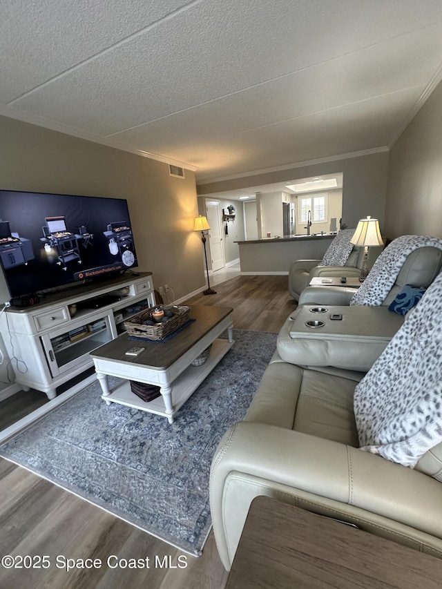 3210 N Harbor City Blvd Unit 316, Melbourne, FL 32935 - living area featuring wood finished floors, ornamental molding, and a textured ceiling