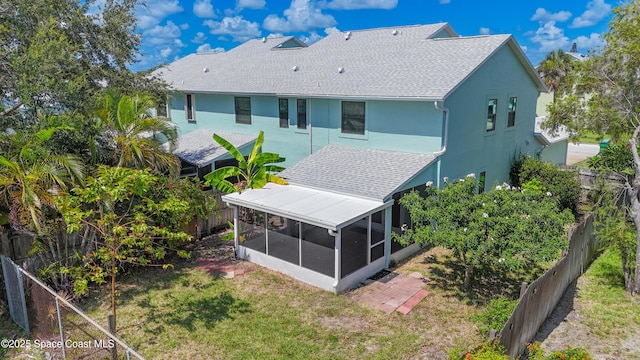 47 Anchor Dr, Indian Harbour Beach, FL 32937 - back of property with a sunroom, a fenced backyard, stucco siding, and roof with shingles