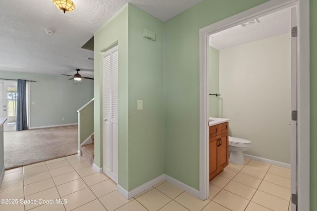 47 Anchor Dr, Indian Harbour Beach, FL 32937 - corridor featuring a textured ceiling, light tile patterned floors, stairs, and light colored carpet