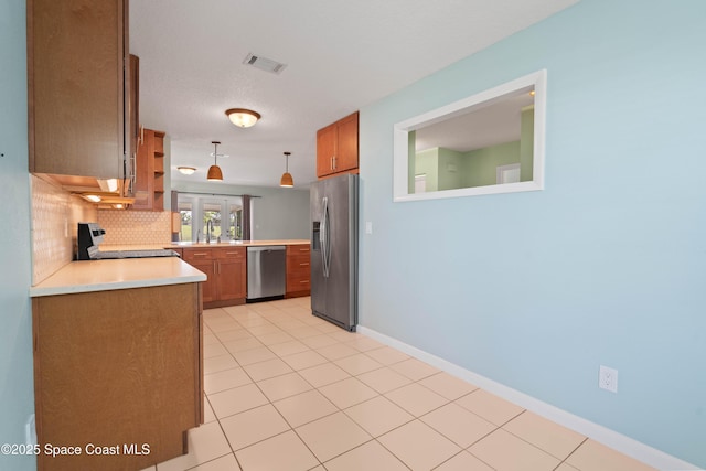 47 Anchor Dr, Indian Harbour Beach, FL 32937 - kitchen with appliances with stainless steel finishes, decorative backsplash, light countertops, and brown cabinetry