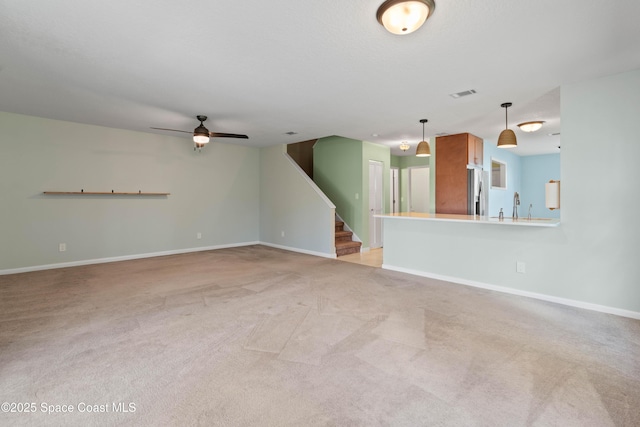 47 Anchor Dr, Indian Harbour Beach, FL 32937 - unfurnished living room with light carpet, stairs, and ceiling fan