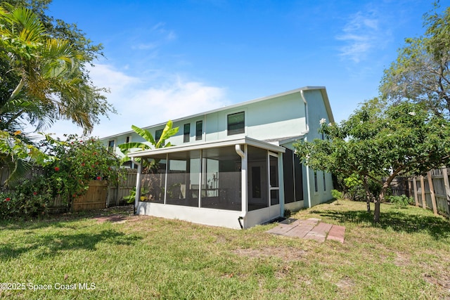 47 Anchor Dr, Indian Harbour Beach, FL 32937 - rear view of house with a sunroom, a fenced backyard, and stucco siding