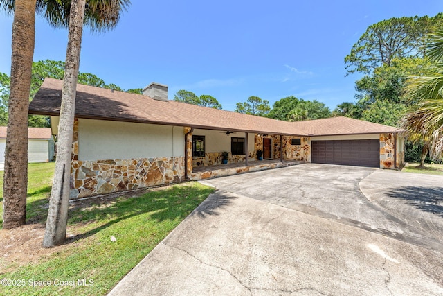 2150 Winston Dr, Cocoa, FL 32926 - view of front of property with stone siding, a garage, a chimney, concrete driveway, and stucco siding