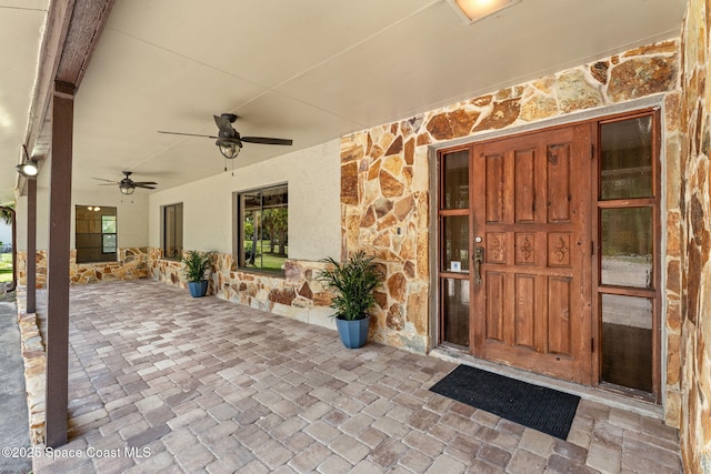 2150 Winston Dr, Cocoa, FL 32926 - property entrance with stone siding, a ceiling fan, and stucco siding