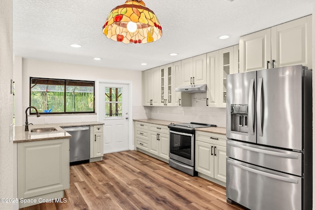 2150 Winston Dr, Cocoa, FL 32926 - kitchen with stainless steel appliances, a textured ceiling, tasteful backsplash, wood finished floors, and white cabinetry