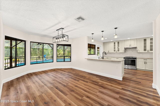 2150 Winston Dr, Cocoa, FL 32926 - kitchen with stainless steel range oven, healthy amount of natural light, tasteful backsplash, dark wood finished floors, and a textured ceiling