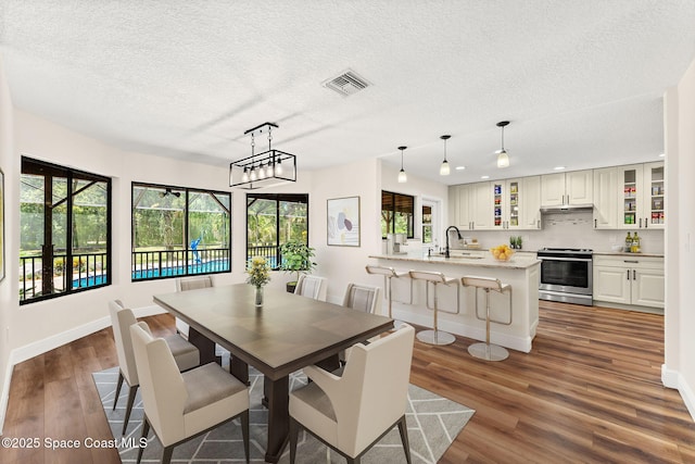 2150 Winston Dr, Cocoa, FL 32926 - dining room with dark wood finished floors, a textured ceiling, healthy amount of natural light, and recessed lighting