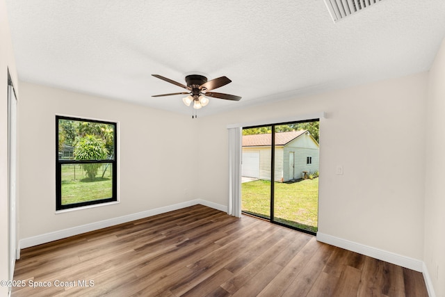 2150 Winston Dr, Cocoa, FL 32926 - unfurnished room featuring healthy amount of natural light, a ceiling fan, wood finished floors, and a textured ceiling