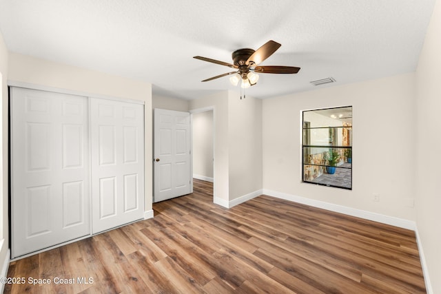 2150 Winston Dr, Cocoa, FL 32926 - unfurnished bedroom with wood finished floors, a closet, a ceiling fan, and a textured ceiling