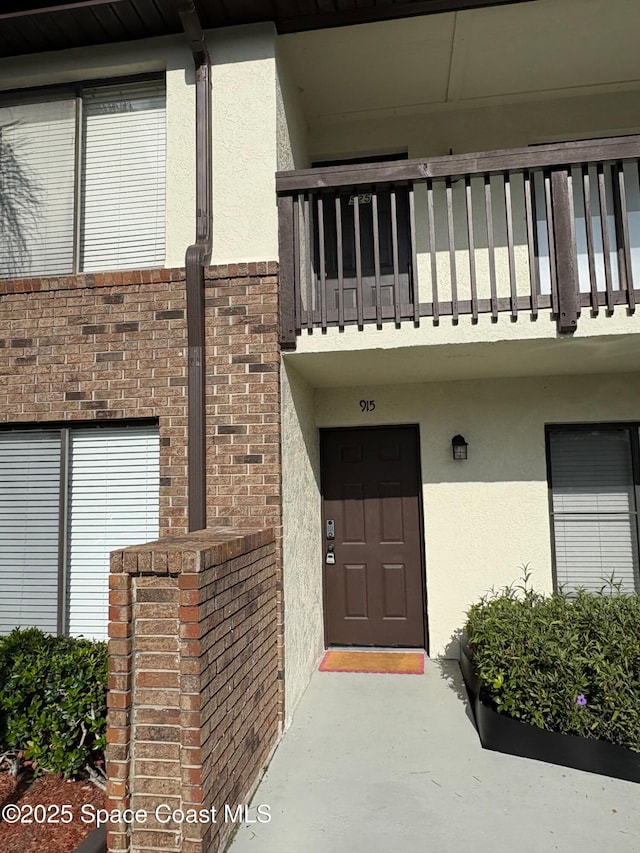 1515 Huntington Ln Unit 915, Rockledge, FL 32955 - view of exterior entry featuring a balcony and stucco siding