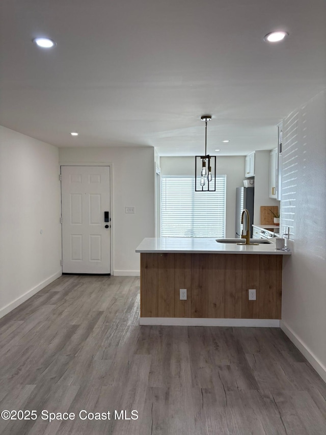 1515 Huntington Ln Unit 915, Rockledge, FL 32955 - kitchen with a peninsula, light wood-style flooring, a chandelier, white cabinetry, and recessed lighting