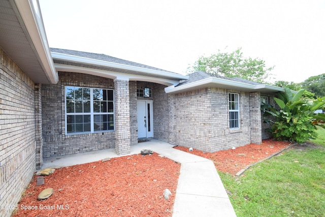 741 Pebble Ave NE, Palm Bay, FL 32907 - doorway to property featuring brick siding and roof with shingles