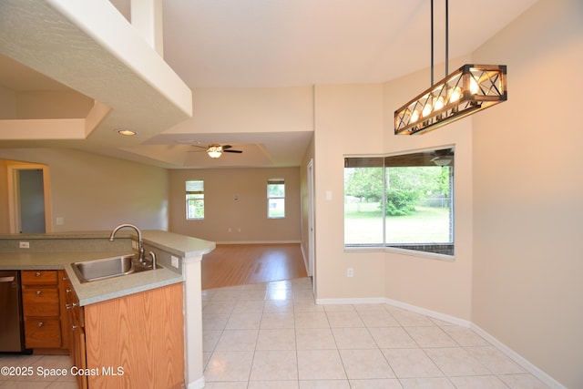 741 Pebble Ave NE, Palm Bay, FL 32907 - kitchen featuring light tile patterned flooring, light countertops, hanging light fixtures, open floor plan, and brown cabinets