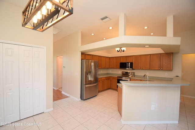741 Pebble Ave NE, Palm Bay, FL 32907 - kitchen with stainless steel appliances, light countertops, brown cabinets, recessed lighting, and a peninsula