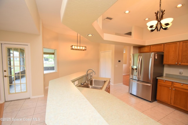 741 Pebble Ave NE, Palm Bay, FL 32907 - kitchen with stainless steel fridge with ice dispenser, a chandelier, brown cabinetry, light tile patterned flooring, and pendant lighting