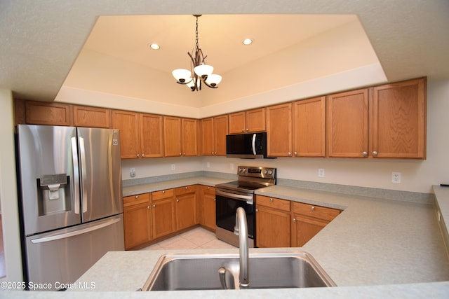 741 Pebble Ave NE, Palm Bay, FL 32907 - kitchen with stainless steel appliances, a tray ceiling, a chandelier, light countertops, and recessed lighting