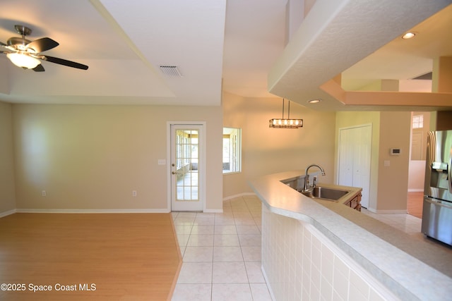 741 Pebble Ave NE, Palm Bay, FL 32907 - kitchen featuring a raised ceiling, stainless steel fridge with ice dispenser, light tile patterned floors, light countertops, and recessed lighting