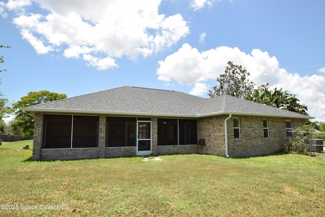 741 Pebble Ave NE, Palm Bay, FL 32907 - back of property featuring a sunroom, brick siding, and a shingled roof