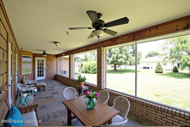 741 Pebble Ave NE, Palm Bay, FL 32907 - sunroom / solarium featuring a ceiling fan, outdoor dining space, plenty of natural light, wood walls, and brick wall