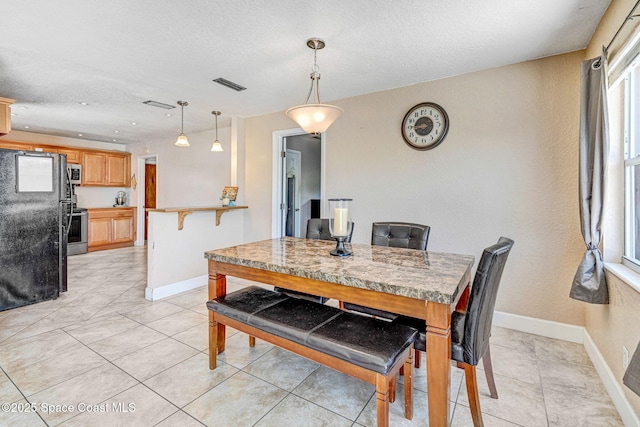 1426 Floyd Dr, Rockledge, FL 32955 - dining space with a textured ceiling and light tile patterned flooring