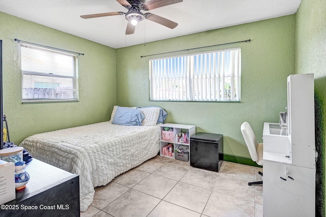1426 Floyd Dr, Rockledge, FL 32955 - bedroom featuring a textured wall, multiple windows, light tile patterned floors, and ceiling fan