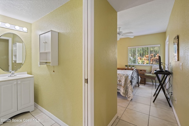 605 Ocean Park Ln Unit V235, Cape Canaveral, FL 32920 - ensuite bathroom featuring a textured wall, vanity, a textured ceiling, ceiling fan, and tile patterned floors