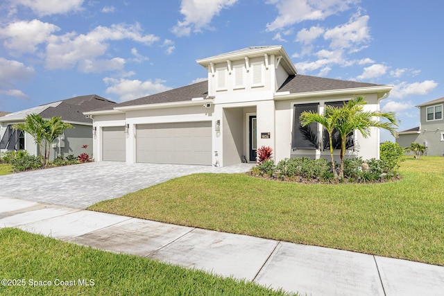 9124 Corvo Ct, Melbourne, FL 32940 - view of front of home with a garage, decorative driveway, a front lawn, and stucco siding