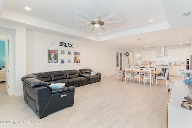 9124 Corvo Ct, Melbourne, FL 32940 - living room featuring a raised ceiling, ceiling fan, recessed lighting, and light wood-style floors