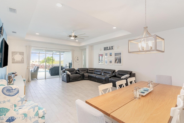 9124 Corvo Ct, Melbourne, FL 32940 - dining space with a raised ceiling, light wood finished floors, ceiling fan, recessed lighting, and a chandelier