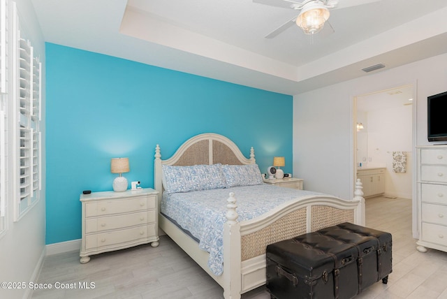 9124 Corvo Ct, Melbourne, FL 32940 - bedroom with light wood-style floors, a raised ceiling, ensuite bathroom, and a ceiling fan