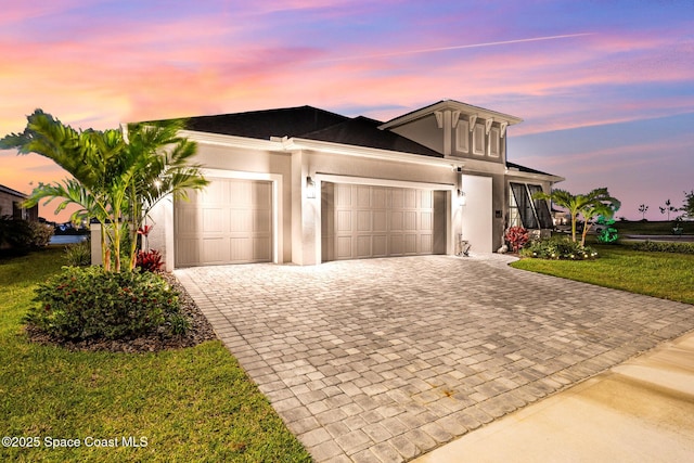 9124 Corvo Ct, Melbourne, FL 32940 - view of front facade featuring an attached garage, decorative driveway, stucco siding, and a front yard