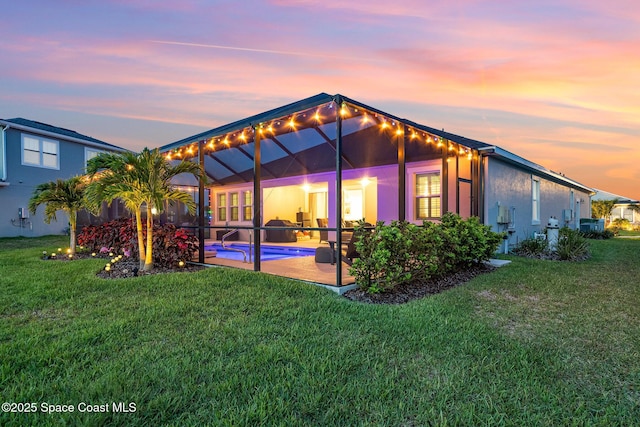 9124 Corvo Ct, Melbourne, FL 32940 - back of property at dusk with an outdoor pool, a yard, a patio area, and glass enclosure