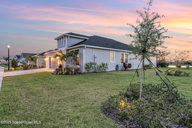 9124 Corvo Ct, Melbourne, FL 32940 - view of front facade with driveway, stucco siding, a lawn, and an attached garage