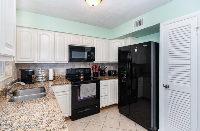 1661 Sandusky St SE, Palm Bay, FL 32909 - kitchen featuring black appliances, white cabinetry, light tile patterned flooring, and backsplash