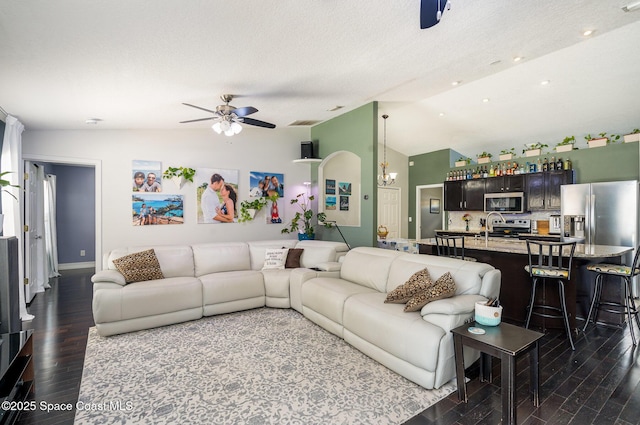 713 Del Mar Cir, Melbourne, FL 32904 - living room with lofted ceiling, dark wood-type flooring, a ceiling fan, and a textured ceiling