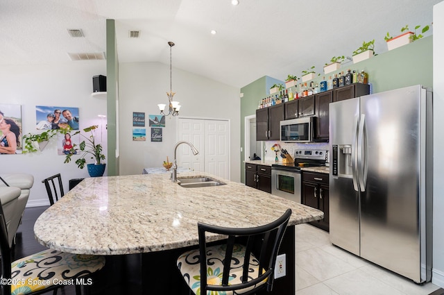 713 Del Mar Cir, Melbourne, FL 32904 - kitchen featuring appliances with stainless steel finishes, lofted ceiling, a breakfast bar area, a chandelier, and hanging light fixtures