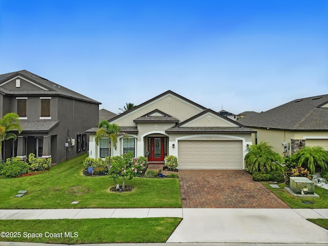 4729 Alligator Flag Cir, West Melbourne, FL 32904 - view of front of home with decorative driveway, a garage, stucco siding, and a front lawn