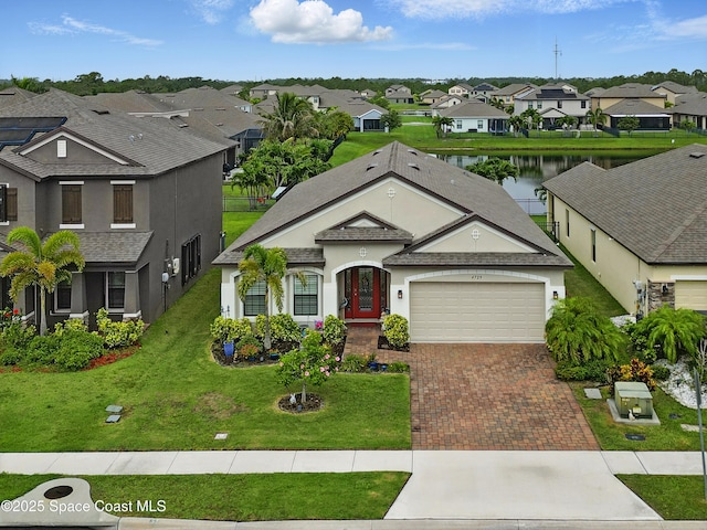 4729 Alligator Flag Cir, West Melbourne, FL 32904 - view of front of house with a residential view, a garage, decorative driveway, stucco siding, and a water view
