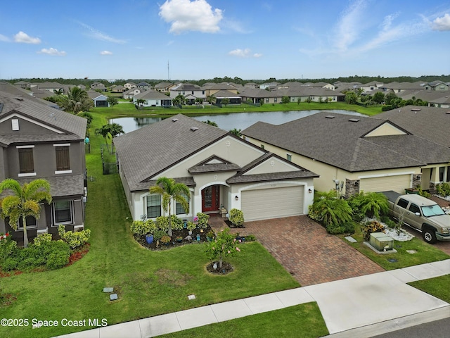 4729 Alligator Flag Cir, West Melbourne, FL 32904 - ranch-style house with a residential view, a garage, decorative driveway, stucco siding, and a water view