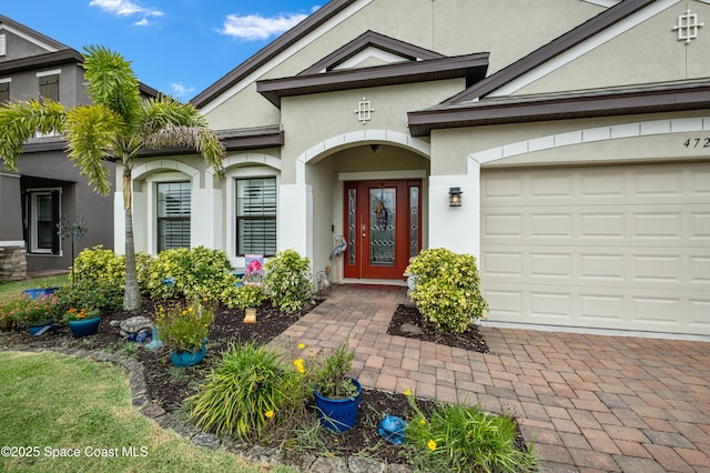 4729 Alligator Flag Cir, West Melbourne, FL 32904 - property entrance featuring stucco siding, driveway, and an attached garage