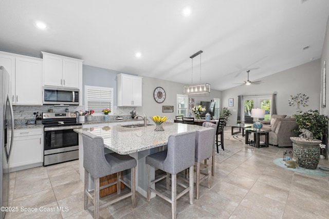 4729 Alligator Flag Cir, West Melbourne, FL 32904 - kitchen with appliances with stainless steel finishes, open floor plan, backsplash, ceiling fan, and light stone counters