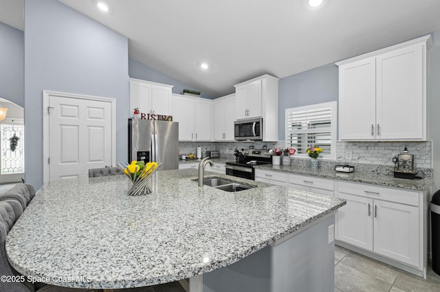 4729 Alligator Flag Cir, West Melbourne, FL 32904 - kitchen with appliances with stainless steel finishes, backsplash, white cabinets, vaulted ceiling, and a spacious island