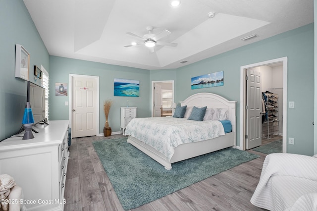4729 Alligator Flag Cir, West Melbourne, FL 32904 - bedroom with a tray ceiling, light wood finished floors, a walk in closet, a ceiling fan, and a closet
