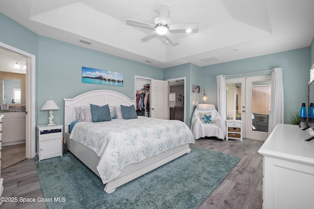 4729 Alligator Flag Cir, West Melbourne, FL 32904 - bedroom with a tray ceiling, wood finished floors, a spacious closet, and access to outside