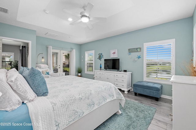 4729 Alligator Flag Cir, West Melbourne, FL 32904 - bedroom featuring french doors, light wood-style floors, a ceiling fan, and a tray ceiling