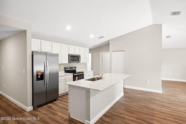 1011 Webster Rd SE, Palm Bay, FL 32909 - kitchen featuring stainless steel appliances, dark wood finished floors, white cabinets, lofted ceiling, and a kitchen island with sink