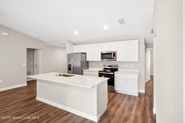 1011 Webster Rd SE, Palm Bay, FL 32909 - kitchen with appliances with stainless steel finishes, white cabinetry, dark wood-style flooring, vaulted ceiling, and recessed lighting